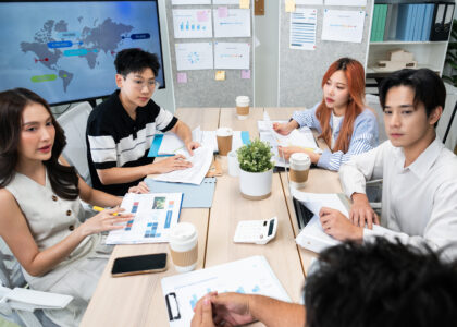 A team discussing strategic HR for business scaling. HR automation dashboard reducing operational friction. Leadership capability development training session in action. Virtual professionals utilizing workplace wellbeing strategies.